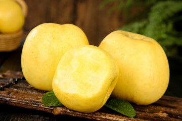 Fresh Golden Fuji Apples with Creamy Flesh on Rustic Wooden Background