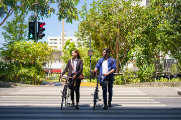 Obraz premium Asian man and woman walking with bicycles in the city on their way to work.