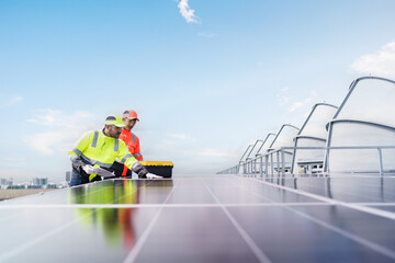 Engineers in safety gear inspecting solar panel installation on office building rooftop. Renewable...