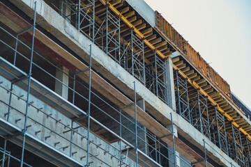 Construction progress of a modern building in an urban area during daylight hours
