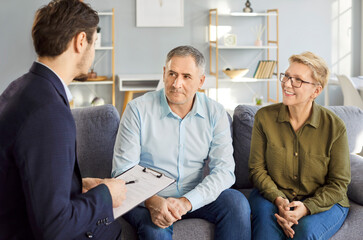 Professional consultant or agent holding a meeting with couple of senior clients in an office,...