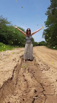 mulher de vestido caminhando em estrada e quando ela passa voam borboletas amarelas