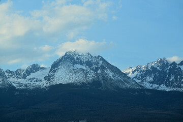 A distant view from the hill of the high peaks of snow-capped mountains High Tatra in spring