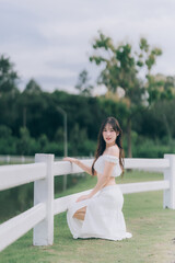 Serene Beauty by the Water's Edge: A graceful figure poses elegantly by a picturesque waterfront,...