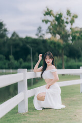 Ethereal serenity: A stunning woman, radiating an aura of elegance, poses in a picturesque outdoor...