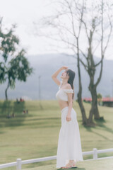 Graceful Serenity in the Open Air: Capturing a woman basking in natural light on a grassy field, an...