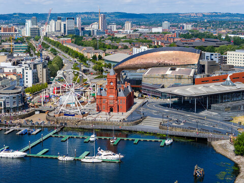 Boats moored in the marina at Cardiff Bay with the Ferris wheel and city behind.