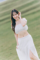 Radiant Portrait in a Grassy Landscape: Capturing the essence of joy, a person exudes happiness, framed against a backdrop of rolling, green hills. The warm daylight casts a beautiful glow.