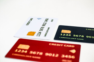 Close-up of white, red and black credit cards on white background suggesting financial transactions