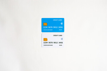 Two modern credit cards displayed on a white surface, highlighting contactless payment technology