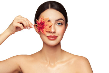 Portrait of beautiful young woman with autumn leafs. Healthy clean fresh skin natural make up beauty eyes