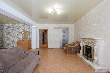 Cozy living room with a sofa, fireplace, and wooden furniture. Light, airy feel