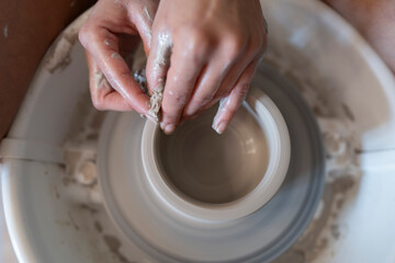 Manos trabajando la ceramica en el torno