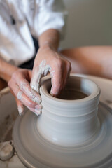 Manos trabajando la ceramica en el torno