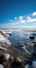 Obraz premium Winter creek flows to a frozen lake