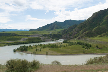 A stormy mountain river is muddy from clay washed down from the mountains.