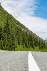 Mountain valley with lush green grass surrounded by mountain ranges covered with clouds