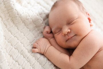Cute newborn baby sleeping on bed indoors