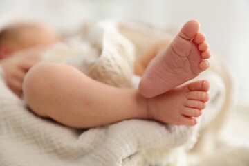 Cute newborn child lying in baby nest indoors, closeup