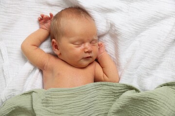 Cute newborn baby sleeping on bed, top view
