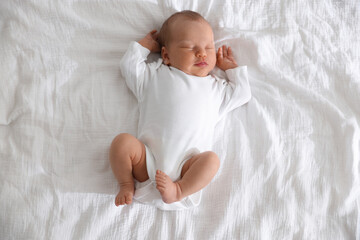 Cute newborn baby sleeping on bed, top view