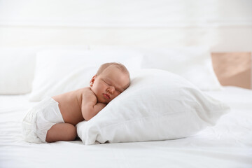 Cute newborn baby sleeping on bed indoors