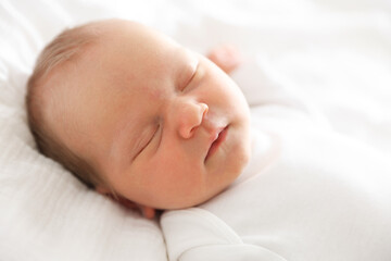 Cute newborn baby sleeping on bed indoors
