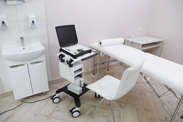 Modern ultrasound machine and examination bed in clinic, above view