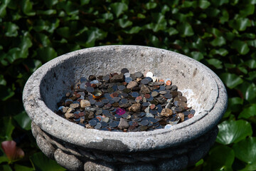 coins in the stone basin at the park