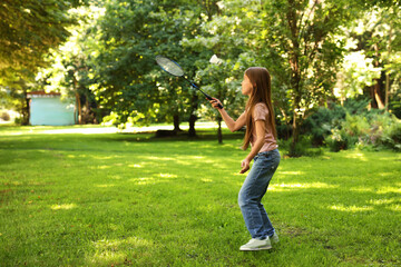 Cute little girl playing badminton in park