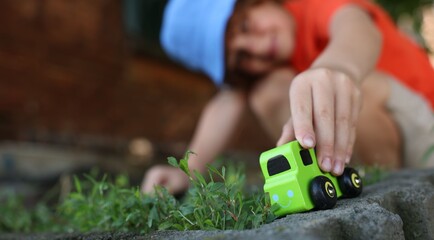 Little boy playing with toy car outdoors, selective focus