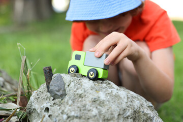Little boy playing with toy car outdoors, closeup