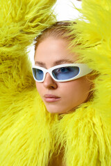Beautiful woman in stylish sunglasses and fur coat posing on white background, closeup