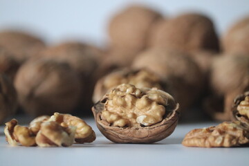 Walnuts in shell and halves in rustic close up, with textures. Winter snack theme of health, warmth