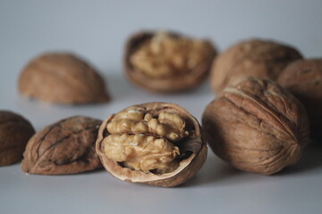 Walnuts in close up, one cracked with kernel, two whole. Winter diet, theme of texture, purity