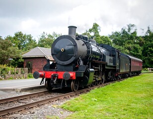 Naklejka premium Vintage steam train at a rural station, UK countryside.