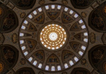 Obraz premium Intricate geometric pattern of an ornate dome ceiling with natural light illuminating the architectural details