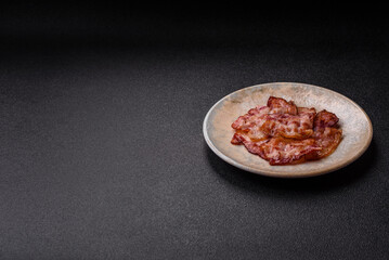 Cooked crispy fried pork bacon strips for a hearty breakfast. Fried bacon strips