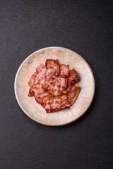 Cooked crispy fried pork bacon strips for a hearty breakfast. Fried bacon strips