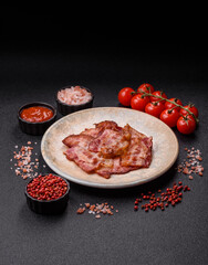 Cooked crispy fried pork bacon strips for a hearty breakfast. Fried bacon strips