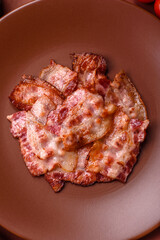 Cooked crispy fried pork bacon strips for a hearty breakfast. Fried bacon strips