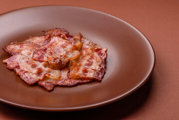Cooked crispy fried pork bacon strips for a hearty breakfast. Fried bacon strips