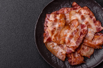 Cooked crispy fried pork bacon strips for a hearty breakfast. Fried bacon strips