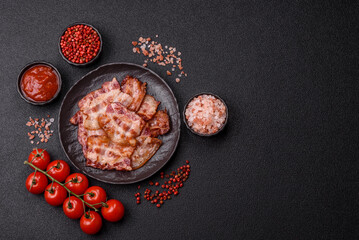 Cooked crispy fried pork bacon strips for a hearty breakfast. Fried bacon strips