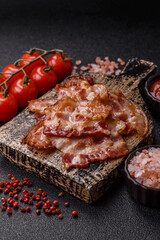 Cooked crispy fried pork bacon strips for a hearty breakfast. Fried bacon strips