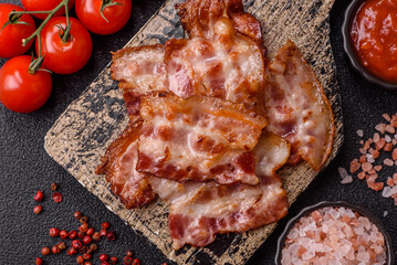 Cooked crispy fried pork bacon strips for a hearty breakfast. Fried bacon strips