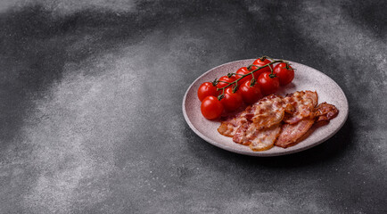 Cooked crispy fried pork bacon strips for a hearty breakfast. Fried bacon strips