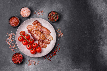 Cooked crispy fried pork bacon strips for a hearty breakfast. Fried bacon strips