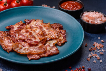 Cooked crispy fried pork bacon strips for a hearty breakfast. Fried bacon strips