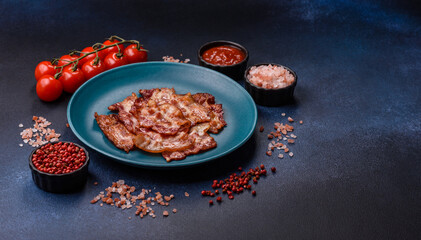 Cooked crispy fried pork bacon strips for a hearty breakfast. Fried bacon strips